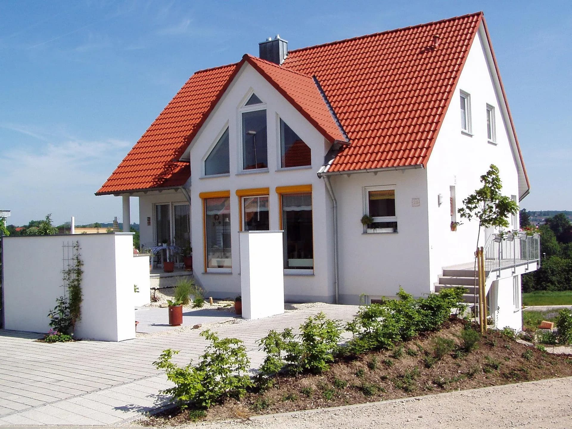 Einfamilienhaus mit rotem Ziegel-Satteldach, Gaube und verglastem Giebel